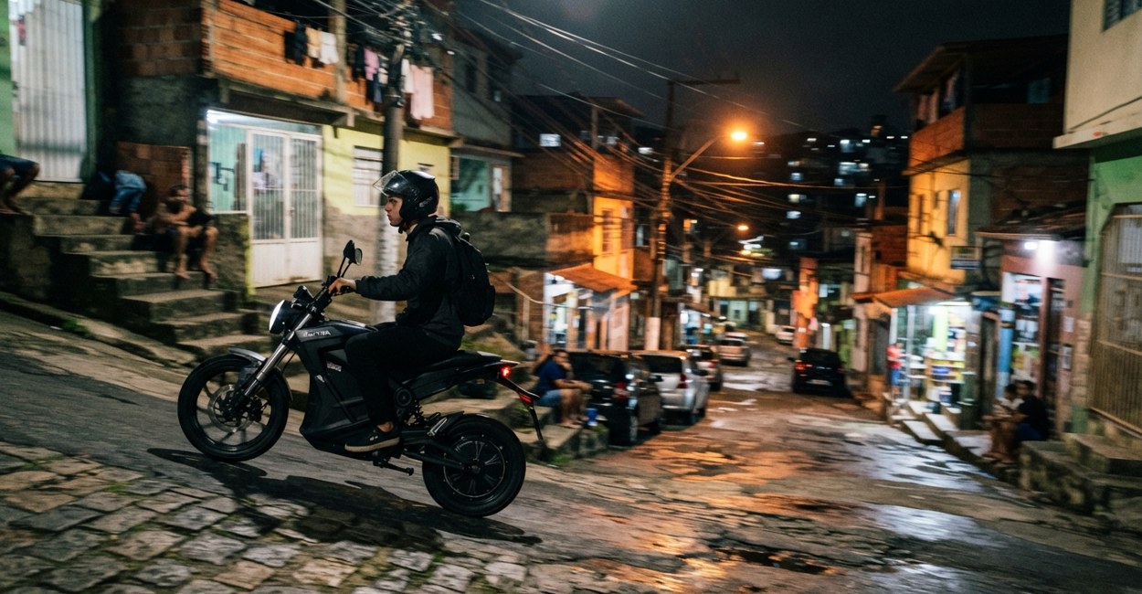Motociclista sobe uma ladeira ingreme de bairro com moto eletrica